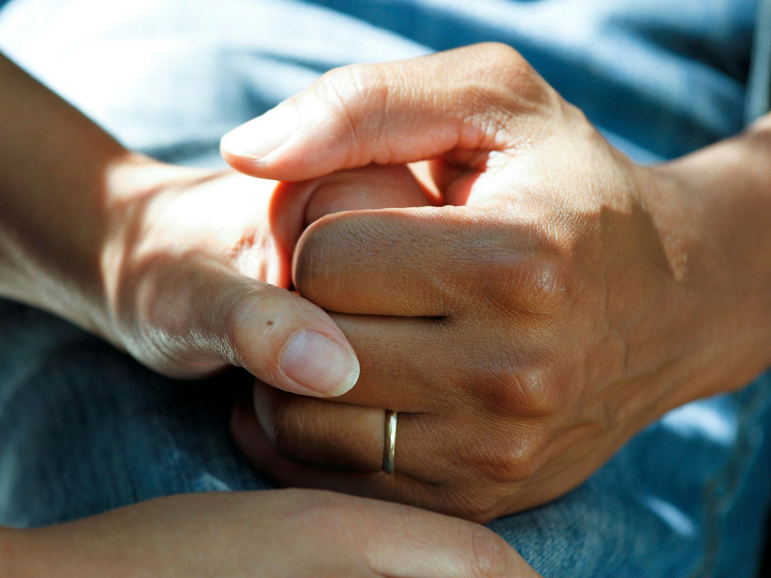 Pflegerin hält die Hand einer älteren Person